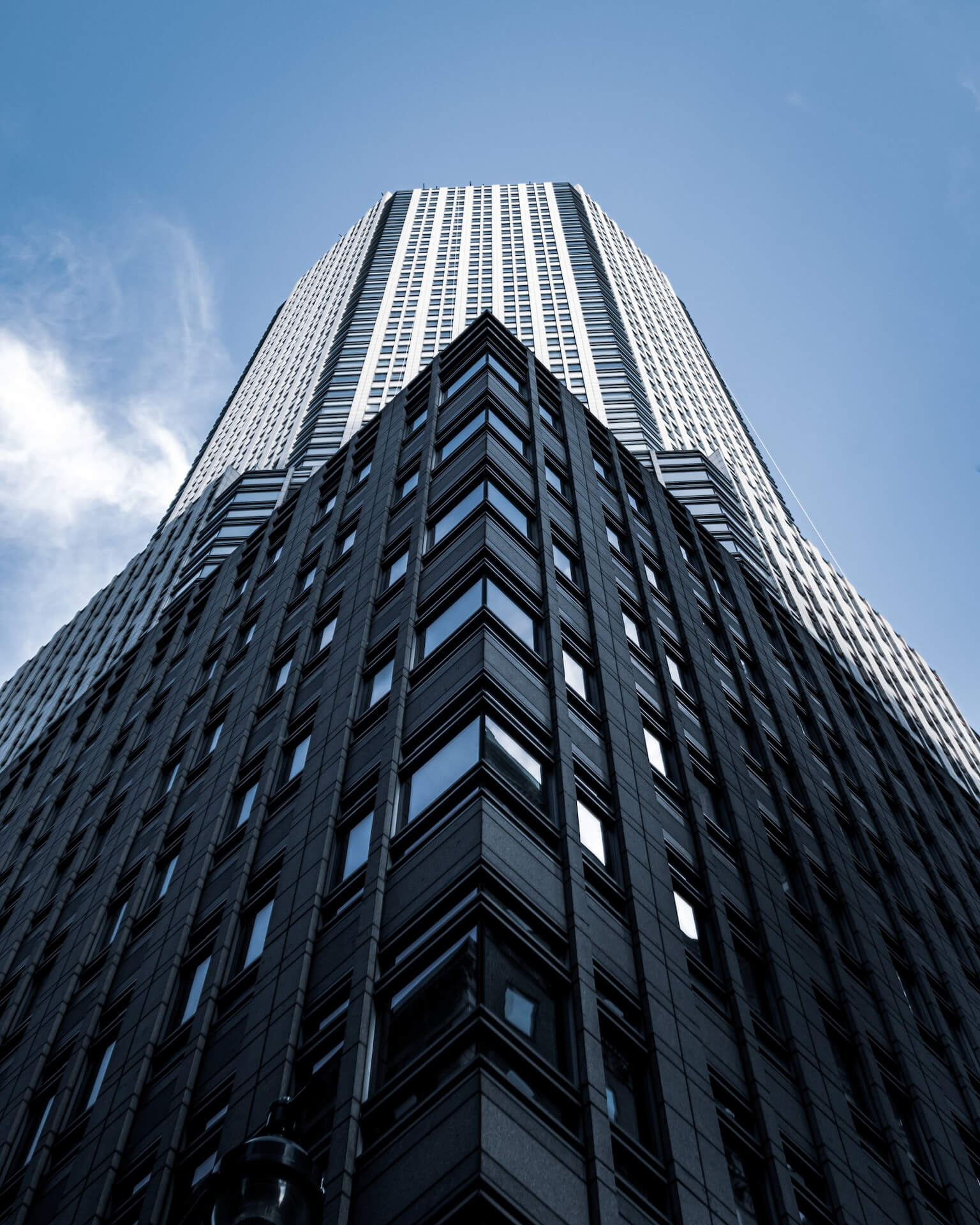 Low-angle view of a high-rise building against a blue sky