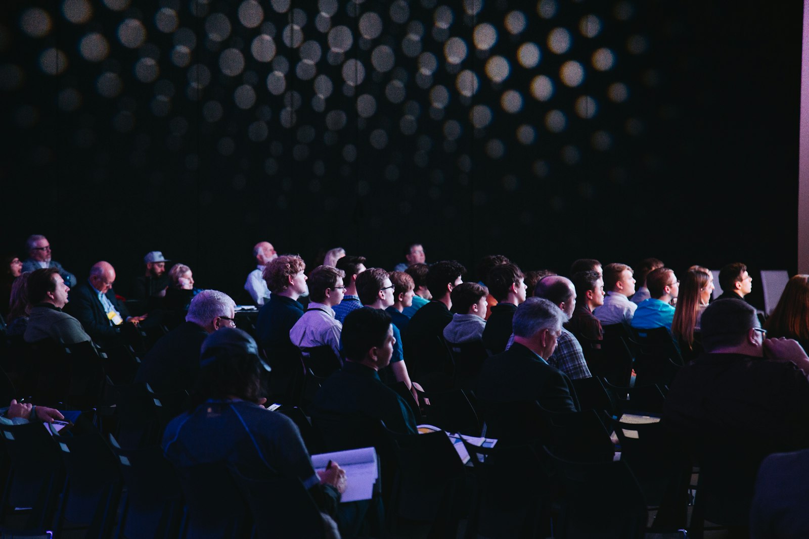 Conference attendees seated in an auditorium listening to a keynote session